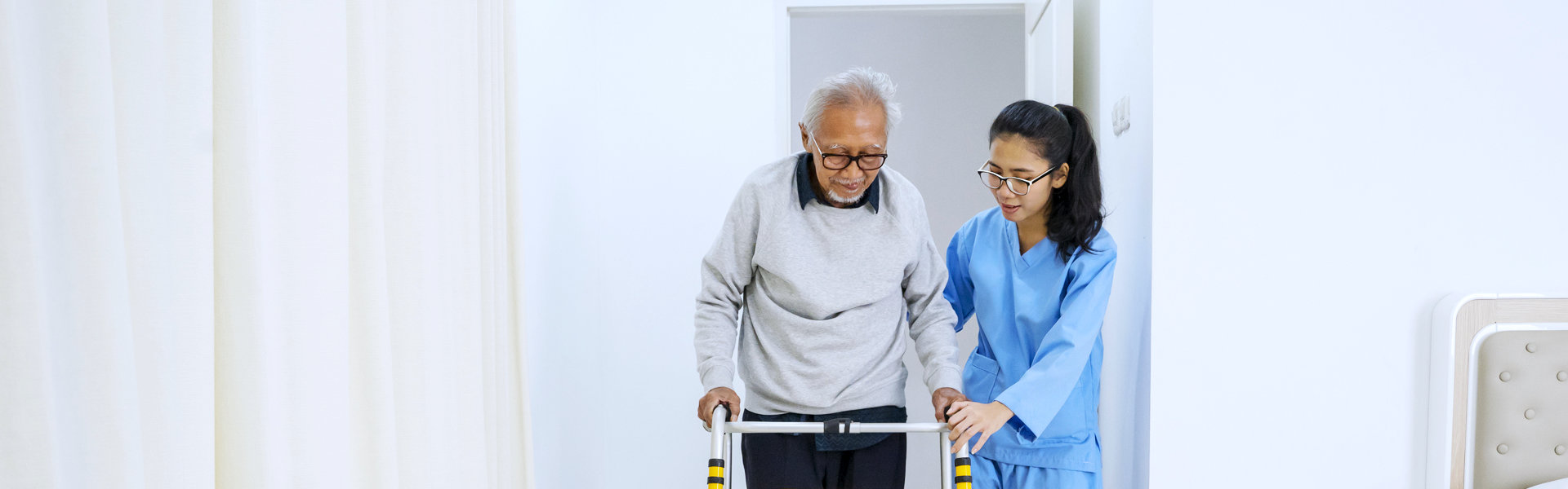 aide assisting an elderly in walking